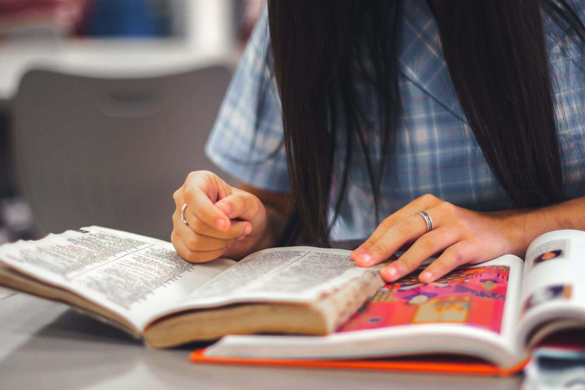 Close-up of hands resting on an open illustrated Bible.